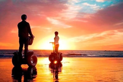 2 people on a segway on the beach