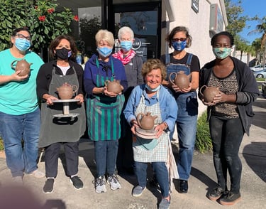 7 people holding pots they made in Sarasota