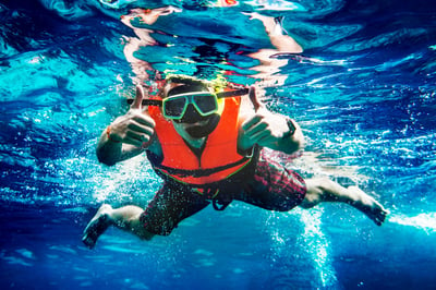 Man in orange life jacket swimming in the water