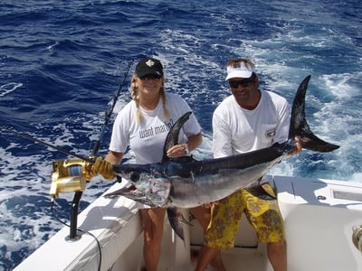 Girl and guy catching a big sword fish