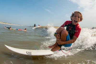 Kid having a blast doing a cannon ball surfing