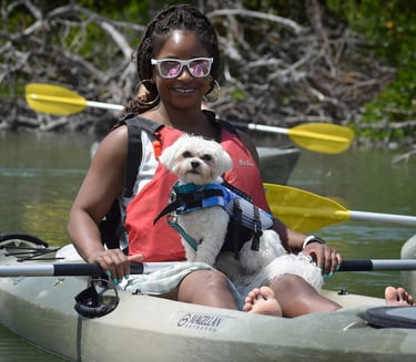 Lady kayaking with little white dog