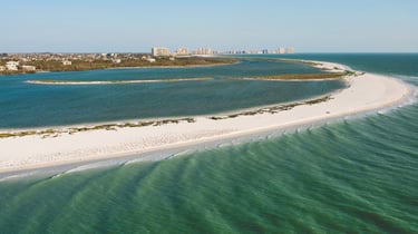 Thin slip of white sand beach with blue water on both sides