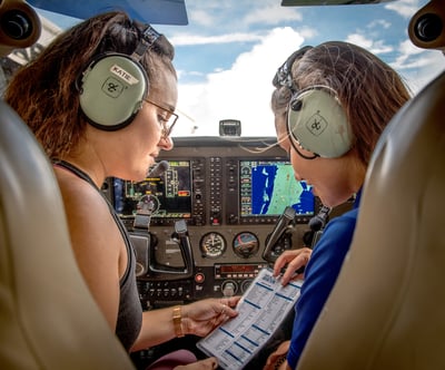 Two girls in the front seats of a helicopter