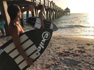 Two people on the beach checking out the waves with surf boards