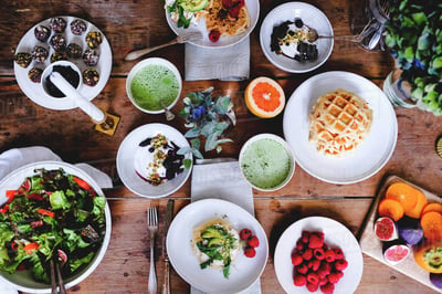 Waffles, smoothies, salad, a table loaded with breakfast food