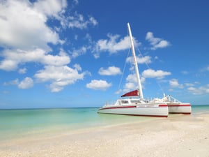 beautiful red and white catamaran on the beach