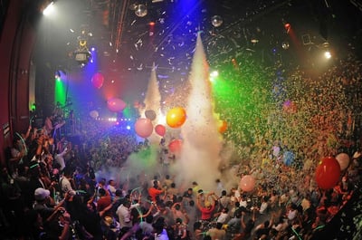 crowded club with ballons and glitter flying in the air