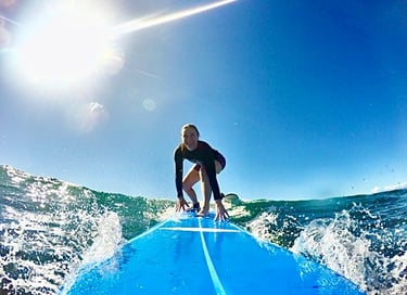 girl surfing on Maui durning Surf Lessons