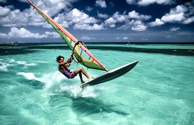 guy windsurfing on crystal clear water