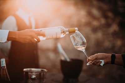 one person pouring wine into another persons glass