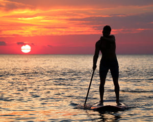 paddleboarder at sunset