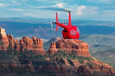 red helicopter over the sedona red rocks