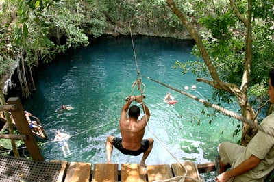 swining off a rope into a water hole 