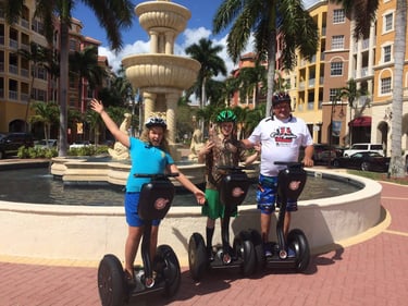 three people segwaying in downtown naples