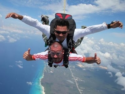 two people sky diving over playa del carmen mexico