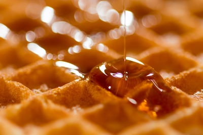 waffle getting syrup poured on it