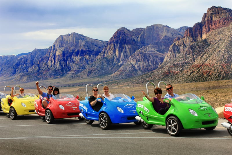 5 mini cars with people in them headed on a Las Vegas tour