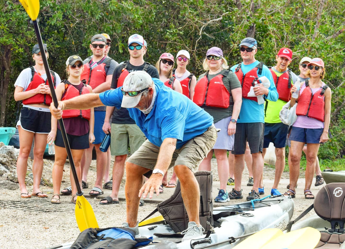 Group of people in red life vests lining up to go kayaking