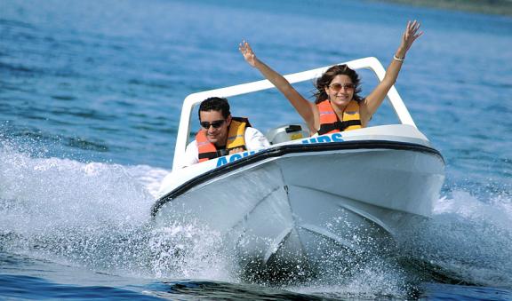 Couple riding a mini speed boat on St Pete Beach