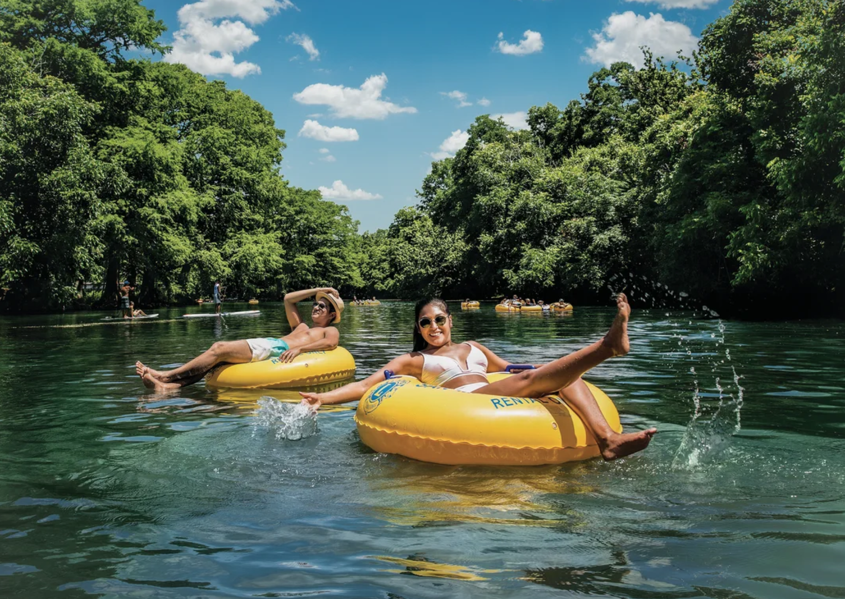 two people on a yellow tubes in the middle of the river