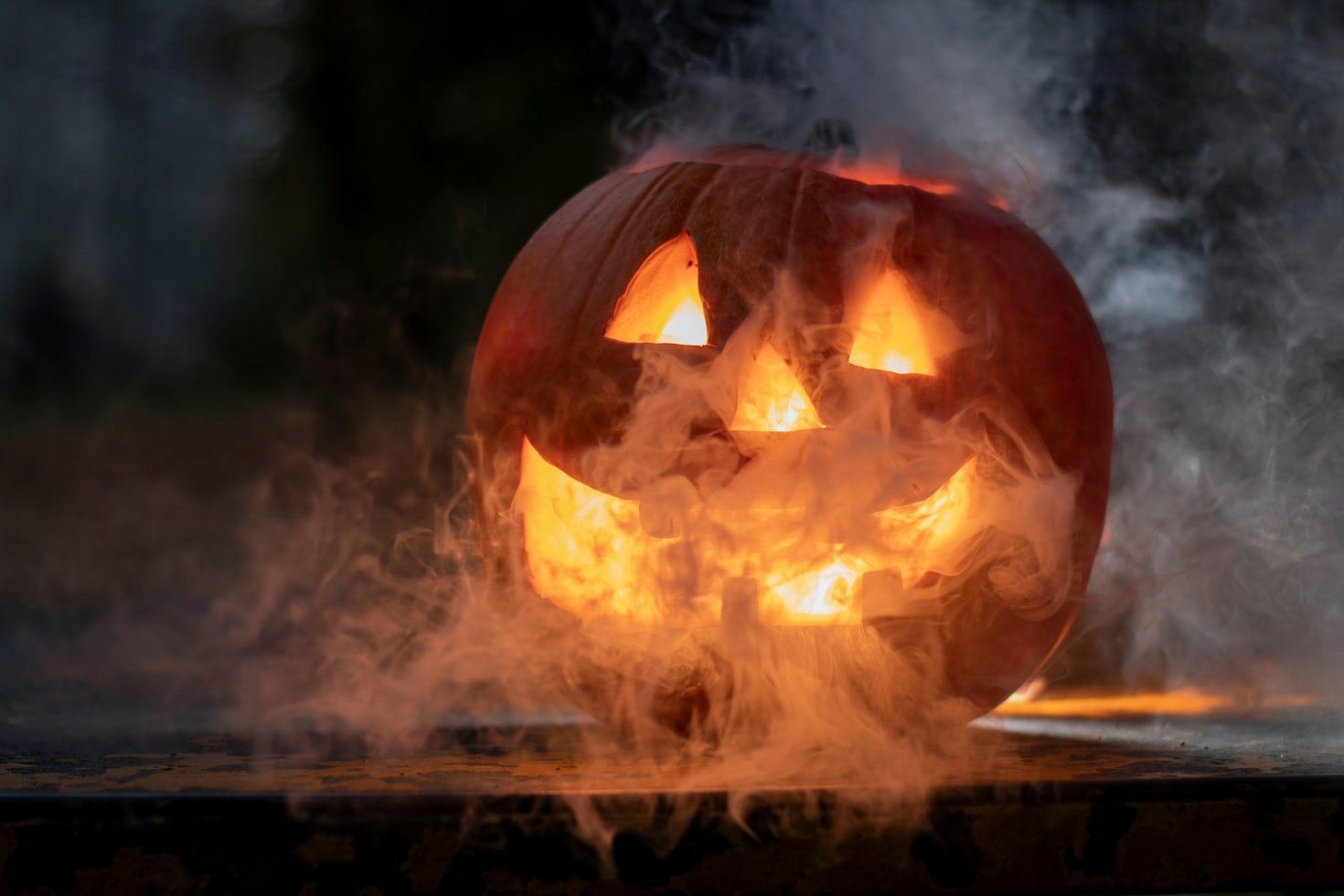 Spooky pumpkin with scary face smoking