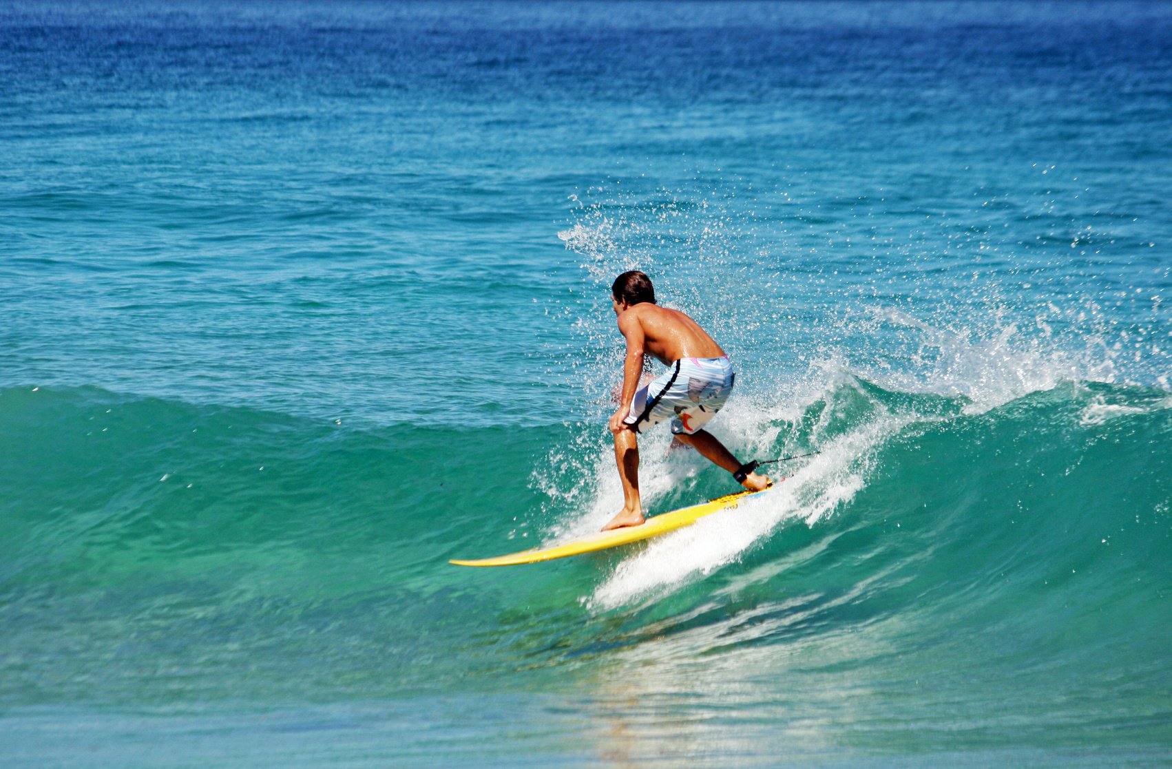 Young guy surfing in Florida on a yellow surf board