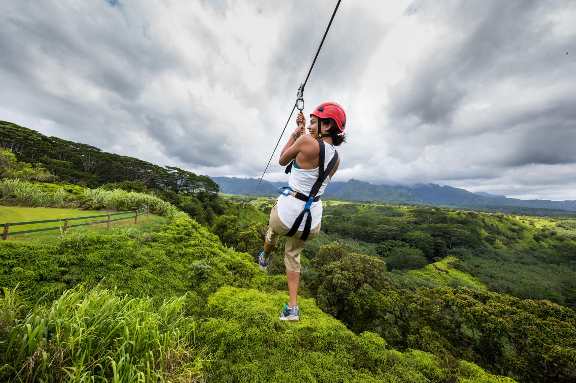 Lady on a zip line high above the tree tops 