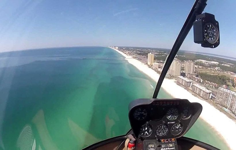 inside a helicopter looking over the beach