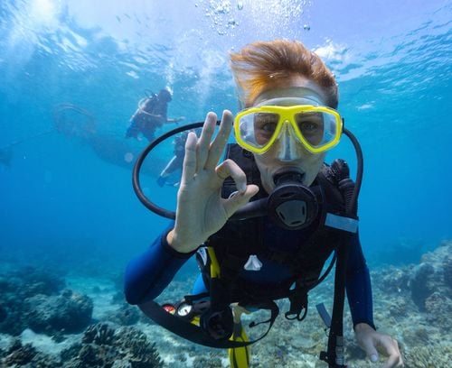 man scuba diving with yellow goggles