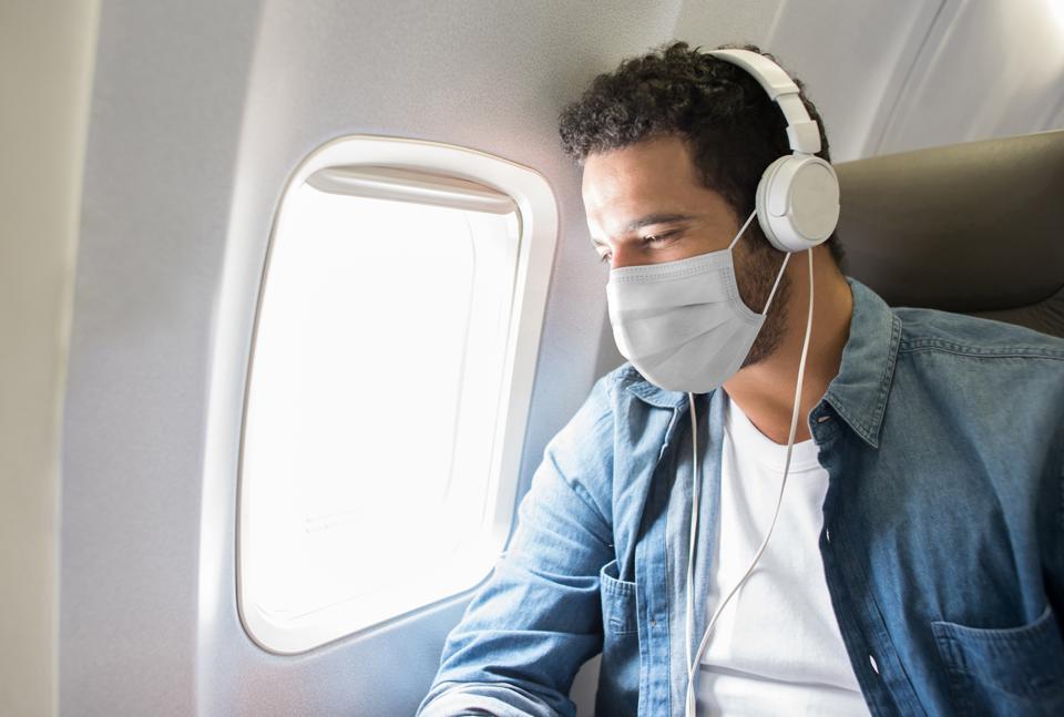 Man wearing a mask on a plane