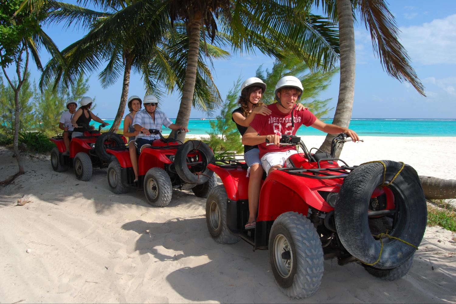 six people on atvs near the beach