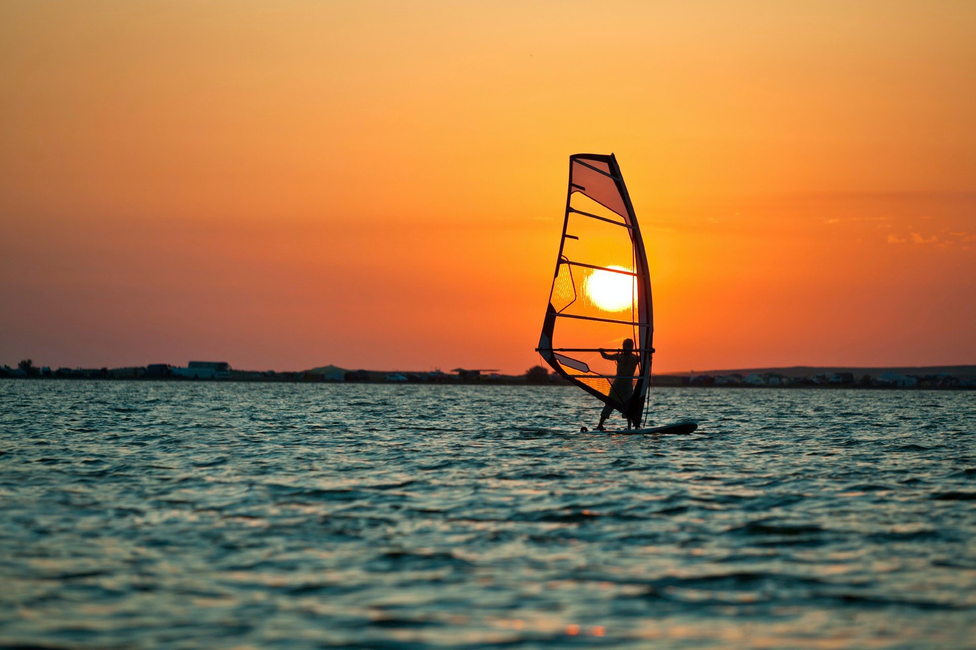 person windsurfing at sunset